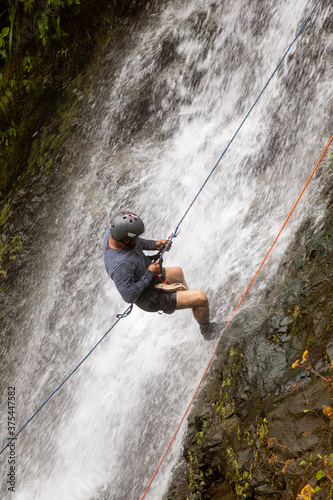 Amateur Man rappelling down a waterfall