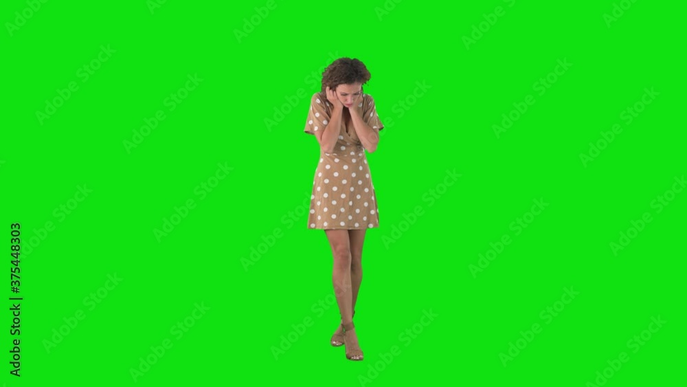 Sad young woman walking and looking down searching something dropped on floor over chroma key green screen. Sad young woman walking and looking down searching something dropped on floor over chroma key green screen.