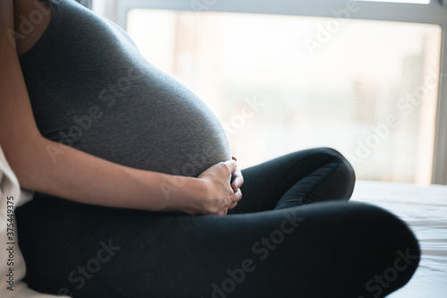 pregnant woman sitting on sofa (ID: 375449375)