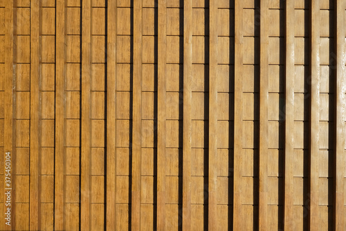 The texture of brown wooden surface. Pattern of wood for furniture, wall or panel.Wooden clapboard background. A wall made of wooden pine panels, covered with a varnish for a background photo