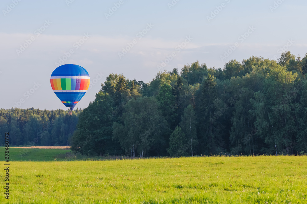 Obraz premium Hot air balloon over the countryside in summer, banner