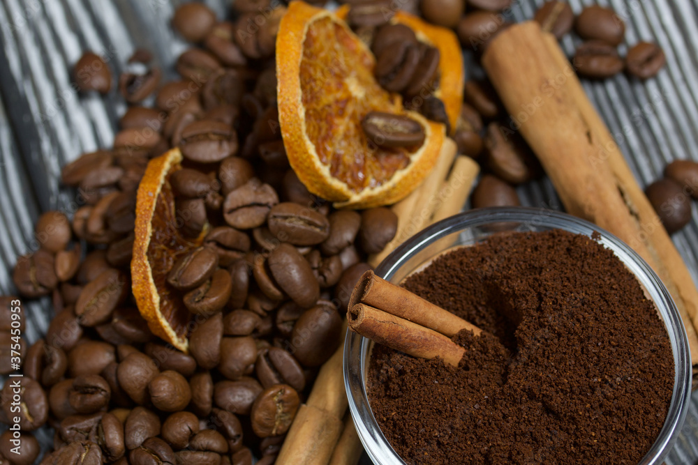 Coffee beans and spices. Ground coffee container. On a surface of brushed pine boards painted black and white. Coffee beans and spices. Ground coffee container. On a surface of brushed pine boards painted black and white.