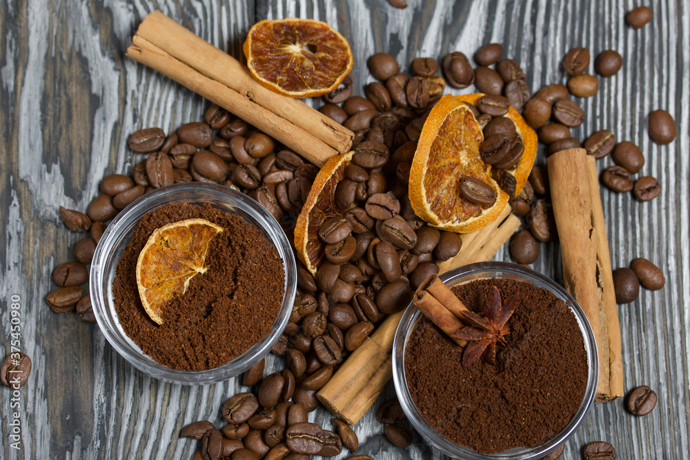 Coffee beans. Ground coffee in containers and spices. On a surface of brushed pine boards painted black and white.