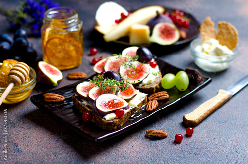 Snack with mascarpone and fig fruits, foreground in focus, with honey, grapes, chees and nuts