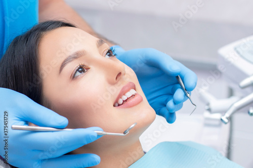 Attractive young woman in a dental clinic with a male dentist. Healthy teeth concept.