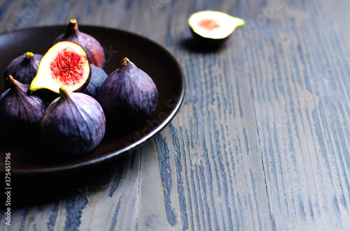 Fig fruit on dark plate, closeup on dark wooden background