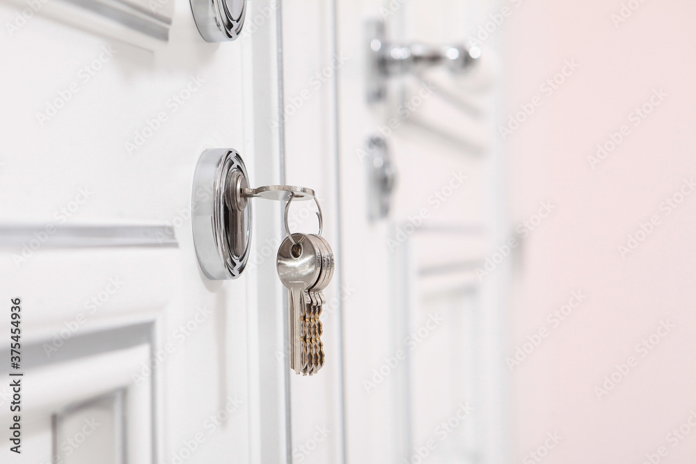 A bunch of keys in the keyhole. White door. Copy space.The concept of new housing.Housewarming.A loan or mortgage. A bunch of keys in the keyhole. White door. Copy space.The concept of new housing.Housewarming.A loan or mortgage.