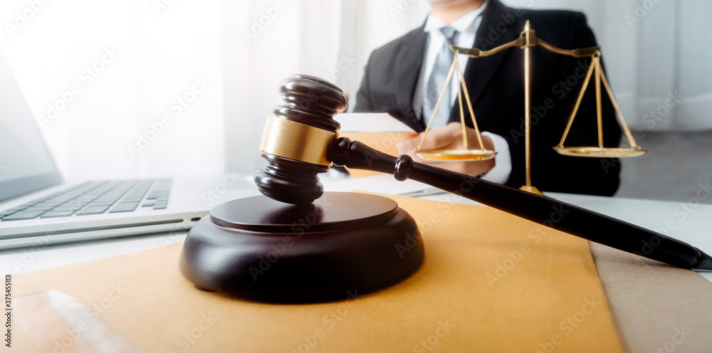 Business and lawyers discussing contract papers with brass scale on desk in office. Law, legal services, advice, justice and law concept picture with film grain effect Business and lawyers discussing contract papers with brass scale on desk in office. Law, legal services, advice, justice and law concept picture with film grain effect