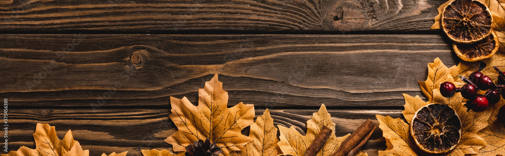 top view of autumnal decoration and foliage on brown wooden background, panoramic shot top view of autumnal decoration and foliage on brown wooden background, panoramic shot