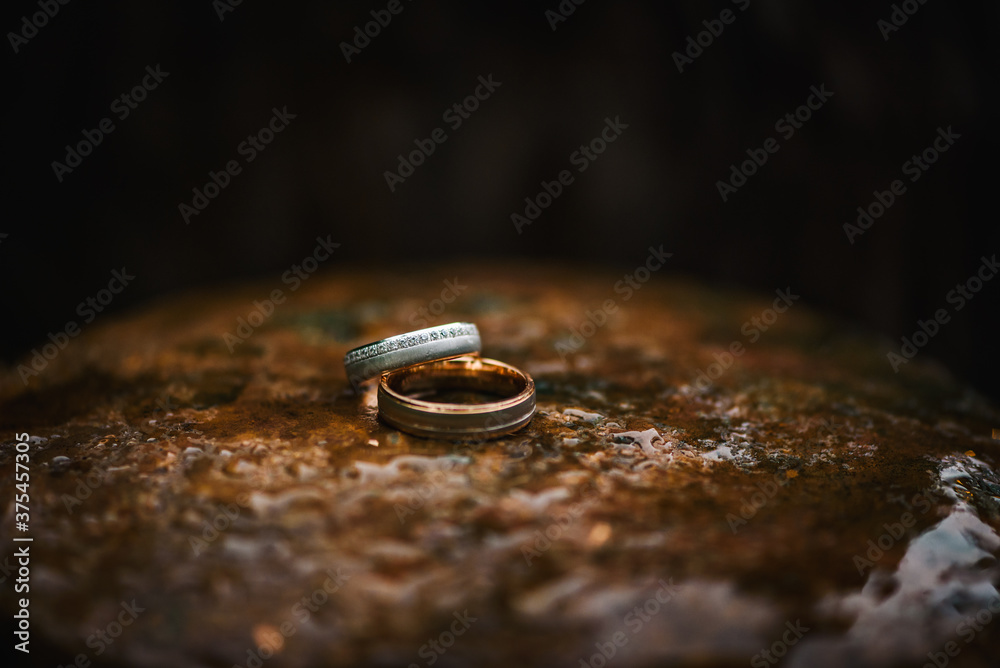 Wedding rings on a table with water drops on it Wedding rings on a table with water drops on it