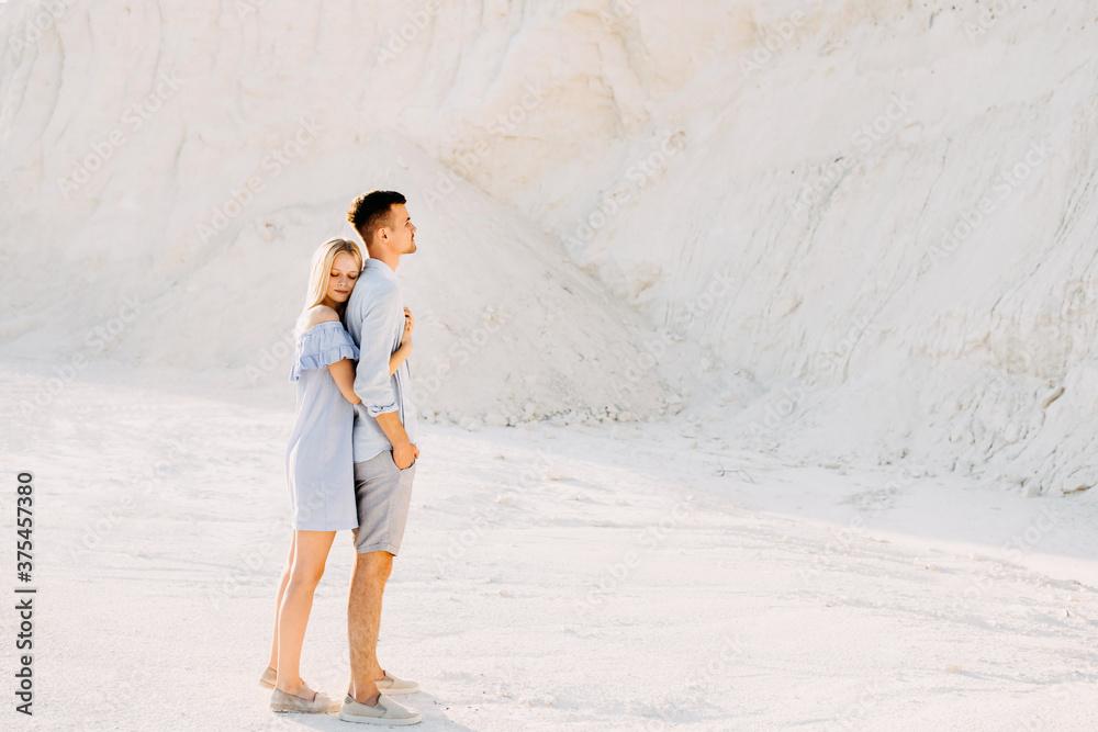 Young romantic couple outdoors. Woman hugging man from behind. Young romantic couple outdoors. Woman hugging man from behind.