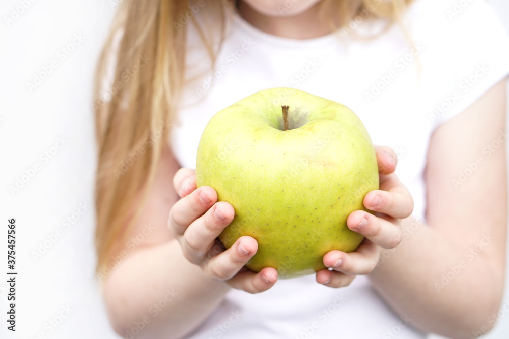Big yellow green apple in children s hands on white background Big yellow green apple in children s hands on white background
