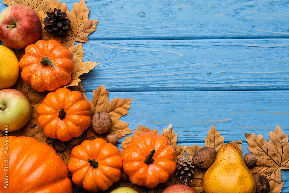 top view of autumnal harvest and foliage on blue wooden background - obrazy, fototapety, plakaty 