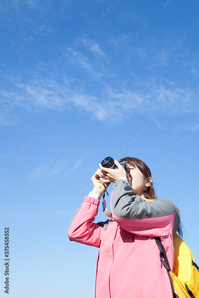 ハイキングして写真撮影する女性