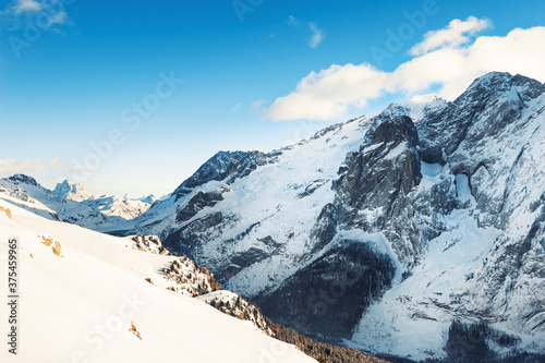 Snow-covered mountains in winter sunny day. Dolomite Alps. Val Di Fassa, Italy. Beautiful winter landscape