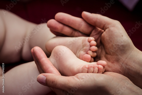 Baby feet in hands of parent