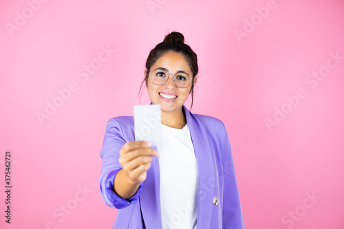 Young beautiful business woman over isolated pink background smiling and holding white card