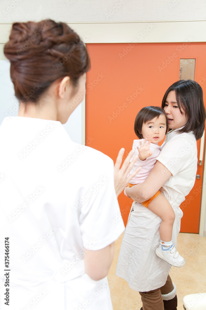 Obraz premium 手を振る看護師と母子