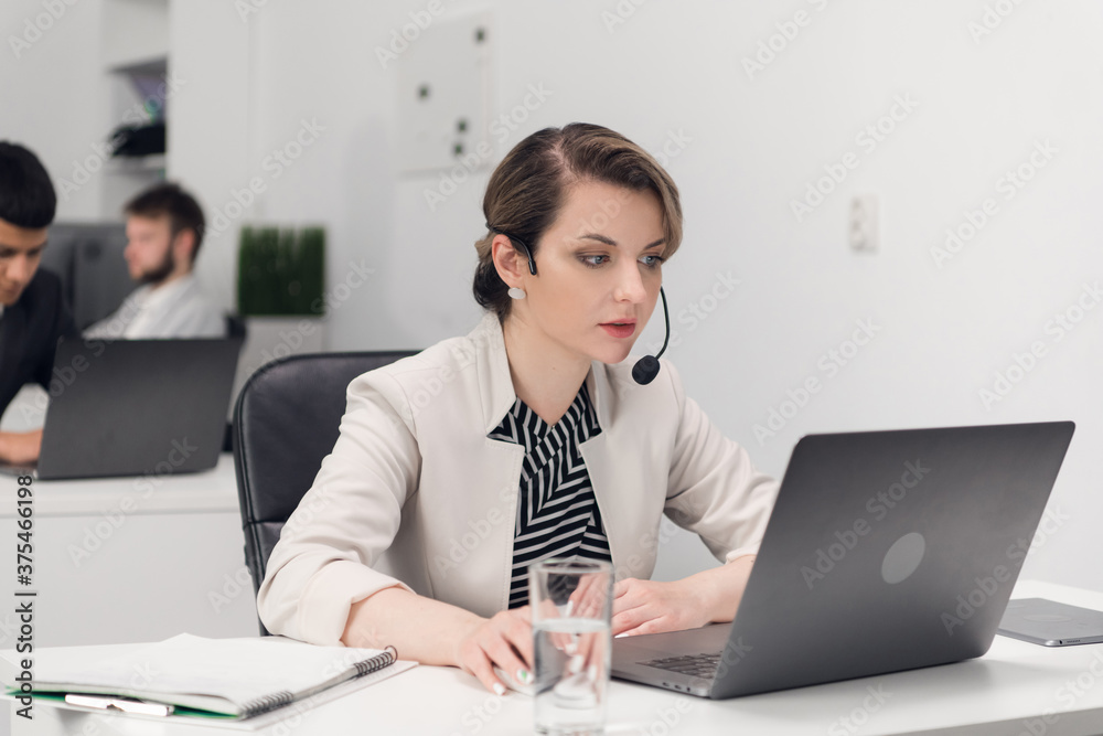Customer service Manager at the workplace at the table with a laptop Customer service Manager at the workplace at the table with a laptop