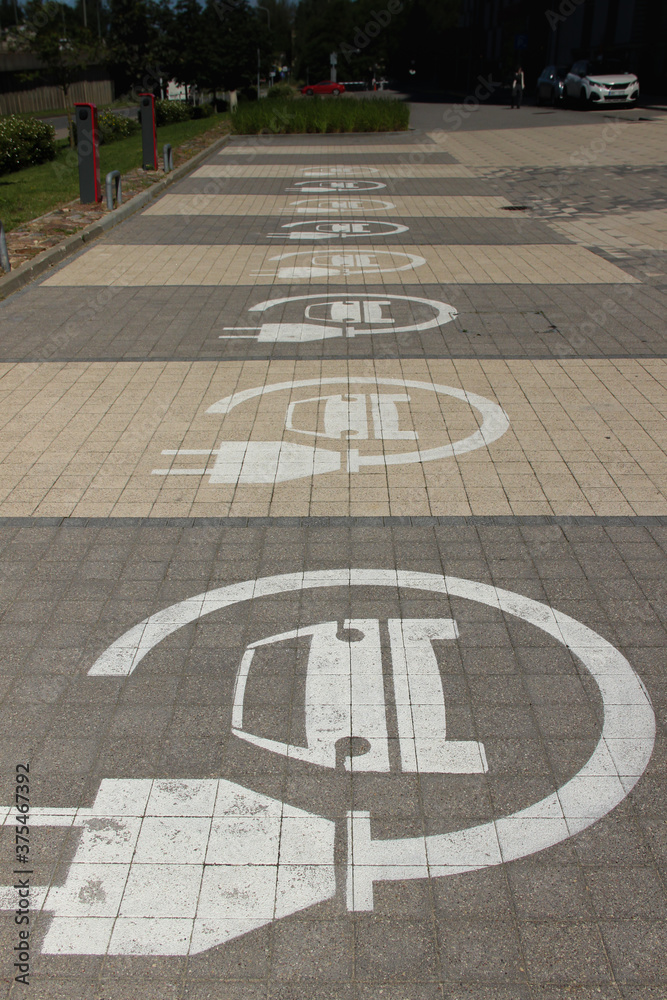 Parking lots for electric cars only. Charging stations stand in a row. Electric car sign.