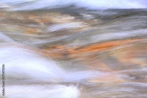 Colorful abstract patterns produced by frozen movement of rushing water in stream. Possible background image.