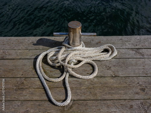 White rope tied to a wooden pole on a bridge