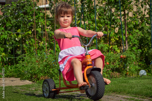 Cute little girl riding tricycle