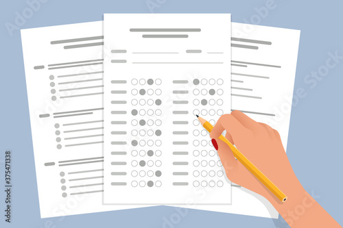 The student filling out answers to exam test answer sheet with a pencil. School and Education. Test score sheet with answers photo