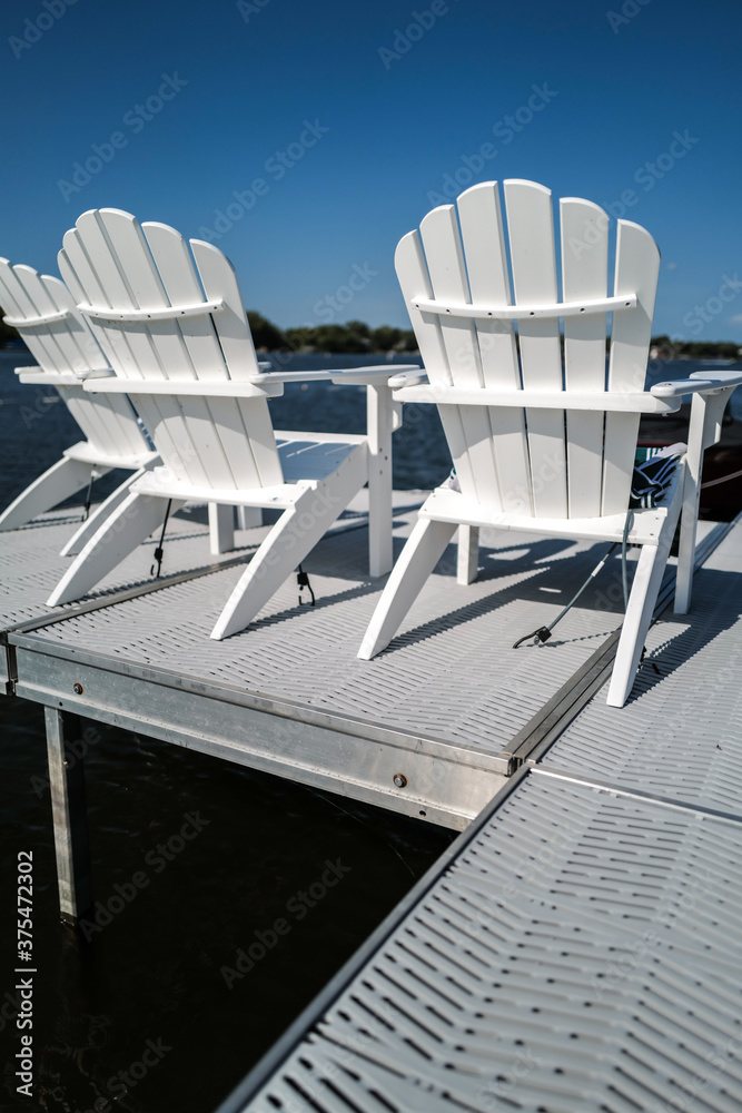 Fototapeta premium empty white chairs along the waterfront dock