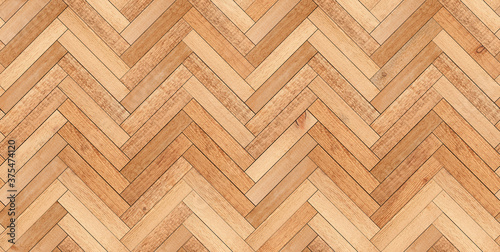 Light wooden boards texture background. Brown seamless parquet floor with herringbone pattern made of narrow planks.