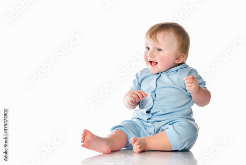 Little boy in a pajama bodysuit is playing in the studio on a white background.