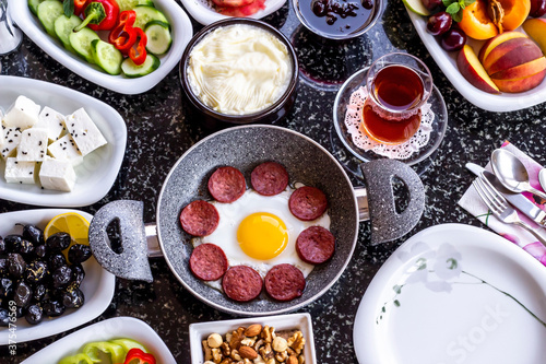 Traditional Turkish Breakfast with sausage egg pan on marble table.Close up taken             