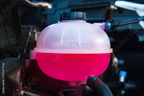 plastic expansion tank of the engine cooling system filled with antifreeze to the required level