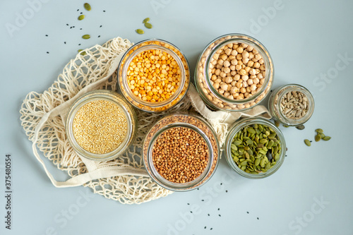 Organic bio bulk products in zero waste shop. Foods storage in kitchen at low waste lifestyle. Cereals and grains in glass jars on table. Eco friendly shopping in plastic free grocery store.