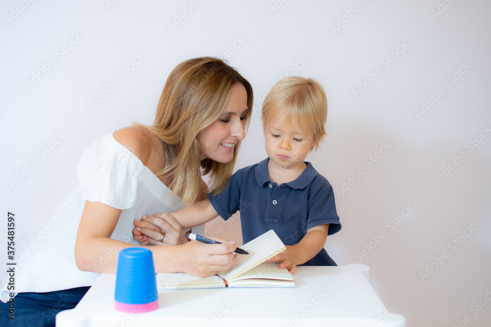 Mother teaching her beautiful baby to draw Mother teaching her beautiful baby to draw