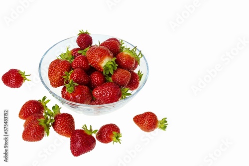Close up view of fresh red strawberry in glass bowl on white background. Healthy food concept.
