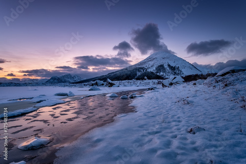 Lofoten islands, Norway. Mountains, ice with snow and clouds during sunset. Evening time. Winter landscape near the ocean. Norway - travel