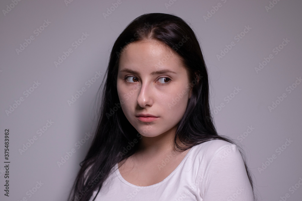 Close up portrait of pretty confident pensive thoughtful girl, looking seriously brunette. on grey background with copy space. People lifestyle concept Close up portrait of pretty confident pensive thoughtful girl, looking seriously brunette. on grey background with copy space. People lifestyle concept