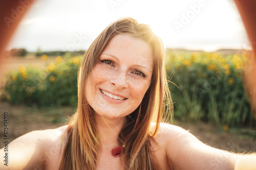 Obraz na plátně Close up portrait of beautiful young woman with long blond hair taking selfie on