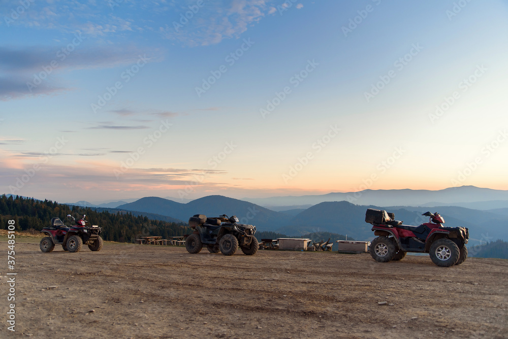 ATV Quad Bikes on the mountain top at sunset landscape background. ATV Quad Bikes on the mountain top at sunset landscape background.