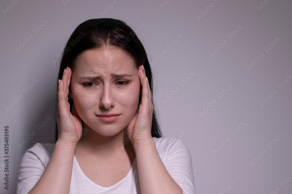 portrait of sad and depressed young woman. on gray background. nervous and upset people concept. portrait of sad and depressed young woman. on gray background. nervous and upset people concept.