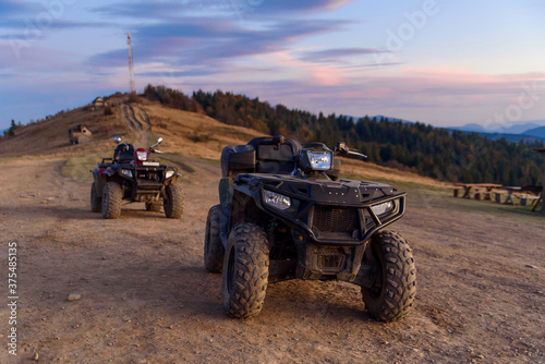 ATV Quad Bikes on the mountain top at sunset landscape background.