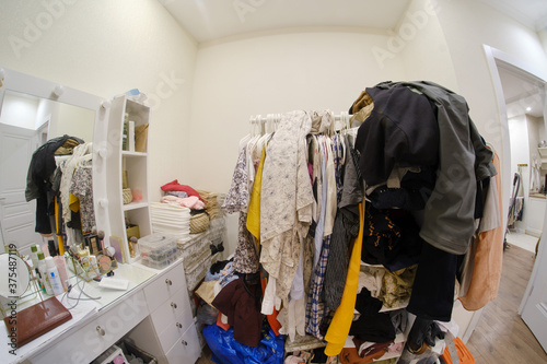 Quadro su tela A room cluttered with clothes and a female dressing table with cosmetics, no clo
