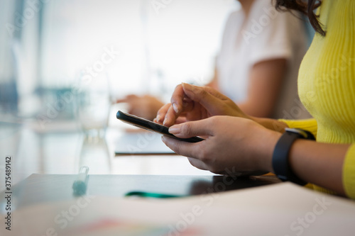 Close up businesswoman using smart phone in meeting