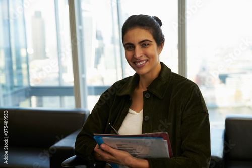 Portrait confident businesswoman with paperwork in office