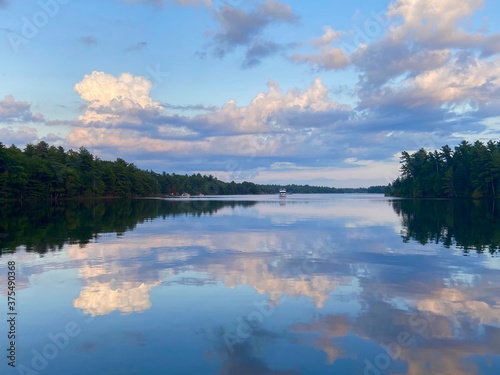 Evening reflection of sky and pine forest in the calm waters of Georgian Bay Ontario Canada