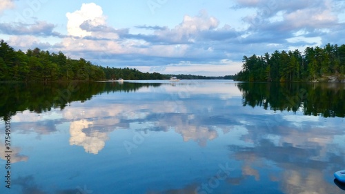 Evening reflection of sky and pine forest in the calm waters of Georgian Bay Ontario Canada