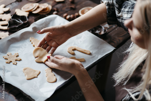 Woman cutting cookies of raw gingerbread dough
