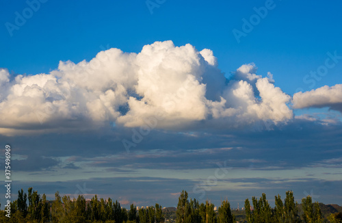 Autumn urban landscape on a Sunny day - yellow autumn trees and bright sky with clouds