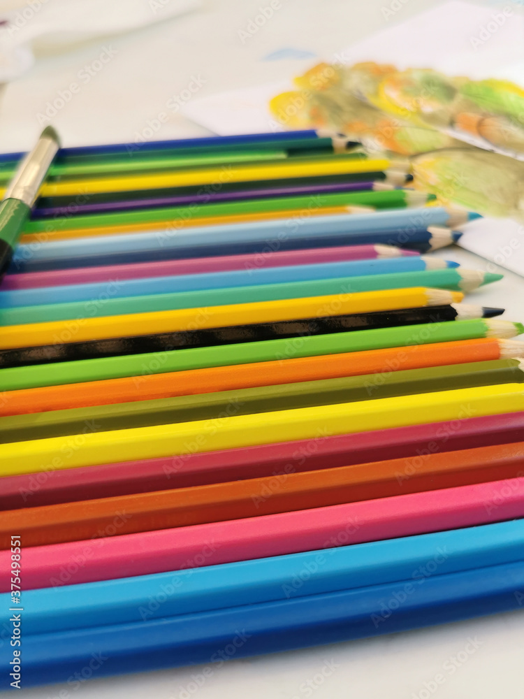 Heap of colored pencils on the white table background Heap of colored pencils on the white table background